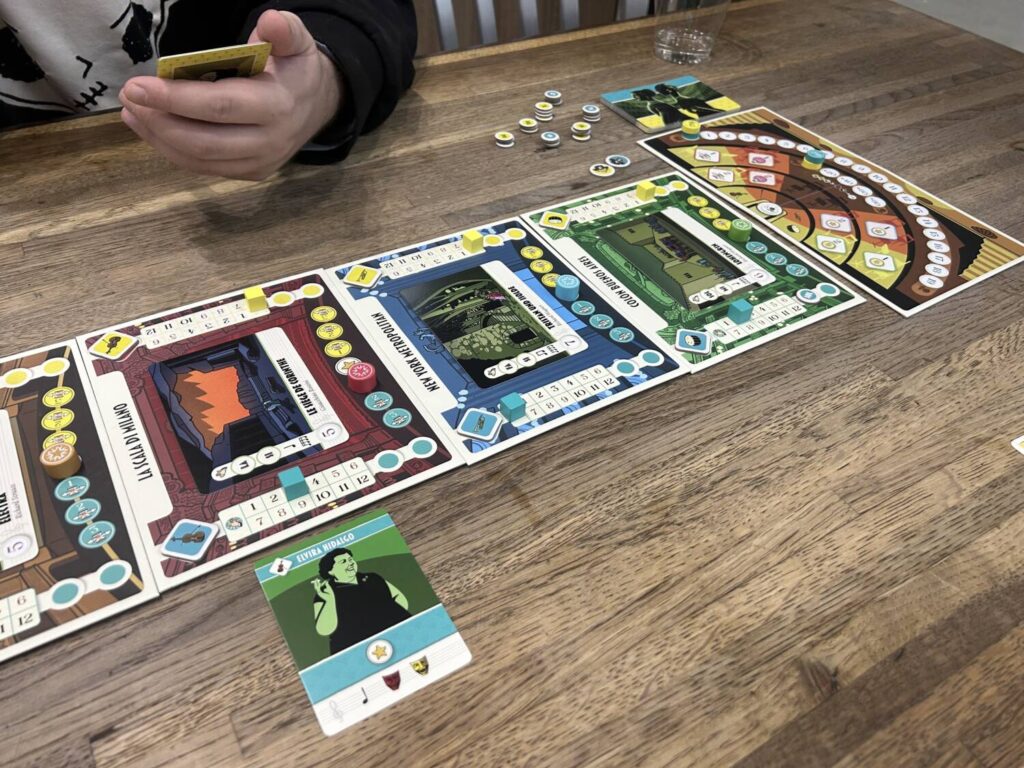 Several individual boards in a row, each depicting an opera house. There are a number of wooden markers.