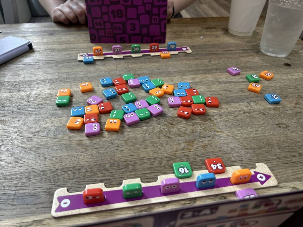A smattering of small, Starburst-sized tiles sit in the middle of a table, in five different colors.
